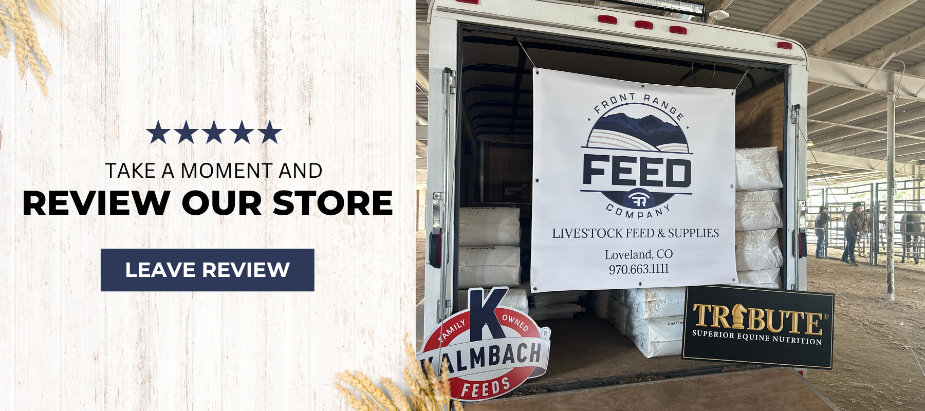 Back of a stock trailer with bags of shavings and a hanging tarp with Front Range Logo, info inside a covered area at a rodeo